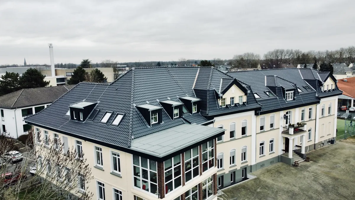 Neu eingedecktes Steildach eines Mehrfamilienhauses, Luftaufnahme