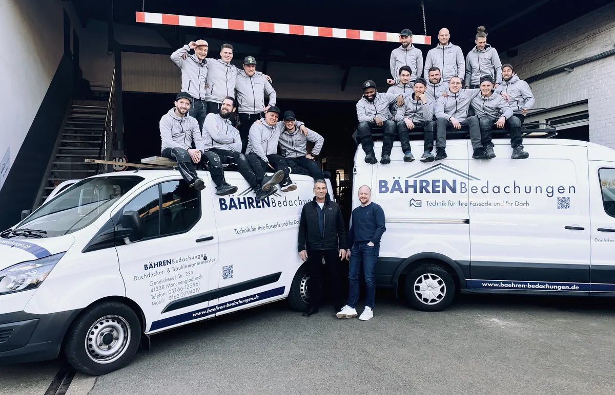 Das Team von Bähren Bedachungen vor den Firmenwagen